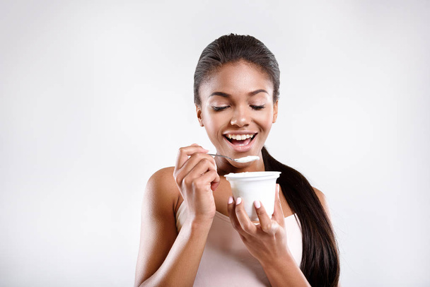 Happy woman is eating yoghurt - Φωτογραφία, εικόνα