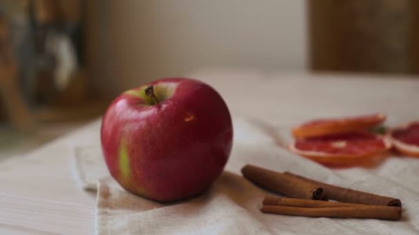 Φρούτα μήλων και ραβδιά κανέλας στο τραπέζι της κουζίνας. Φέτες μήλου και γκρέιπφρουτ - Πλάνα, βίντεο