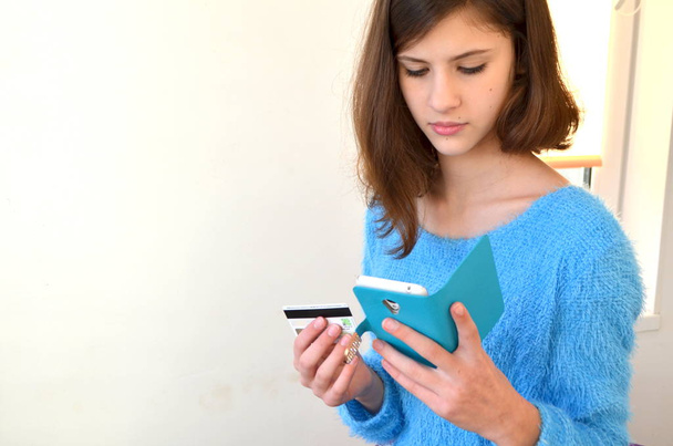 Girl with credit card and telephone. Shopping in the online shop - Photo, Image