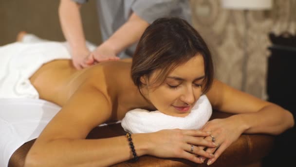mladá bruneta žena dostává masáž zad - Záběry, video