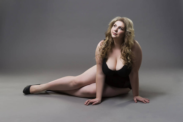Young beautiful blonde plus size model with big natural breasts in underwear, xxl woman on gray studio background - Φωτογραφία, εικόνα