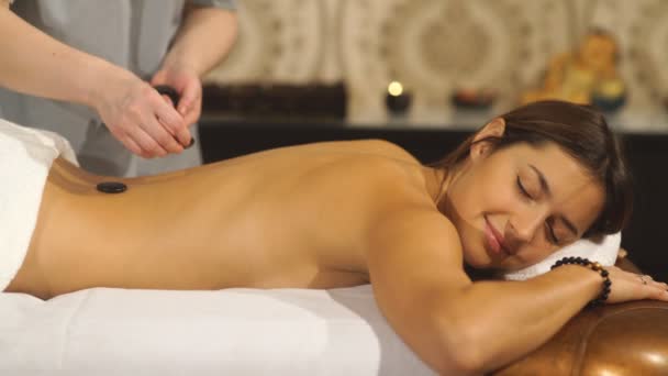 Girl on a stone therapy, hot stone massage - Záběry, video