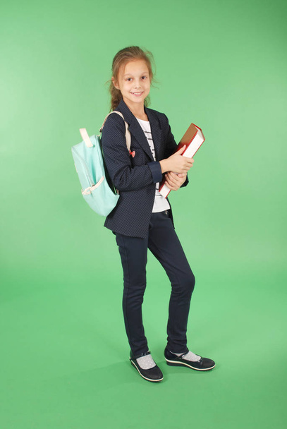 Young school girl with red book and backpack - Foto, afbeelding