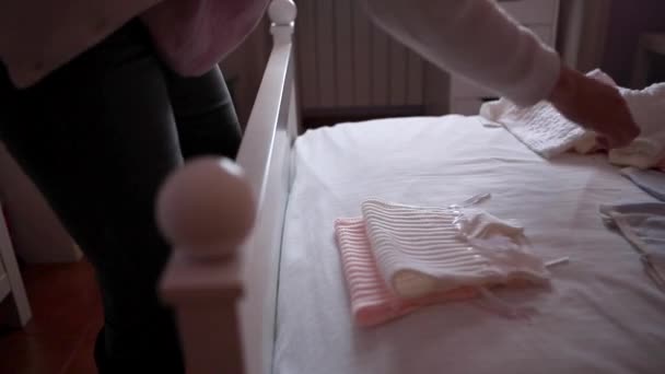 Vrouwen zorgvuldig opstellen van kleding van de baby - Video
