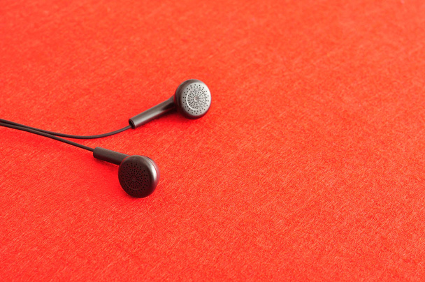 Ακουστικά που απομονώνονται σε κόκκινο φόντο - Φωτογραφία, εικόνα