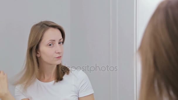 Jeune jolie femme fixant ses cheveux
 - Séquence, vidéo