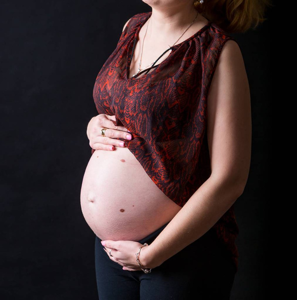 Pregnant women showing her belly - Φωτογραφία, εικόνα