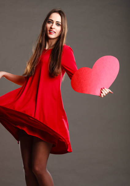 Woman in red dress holds heart sign - Фото, зображення