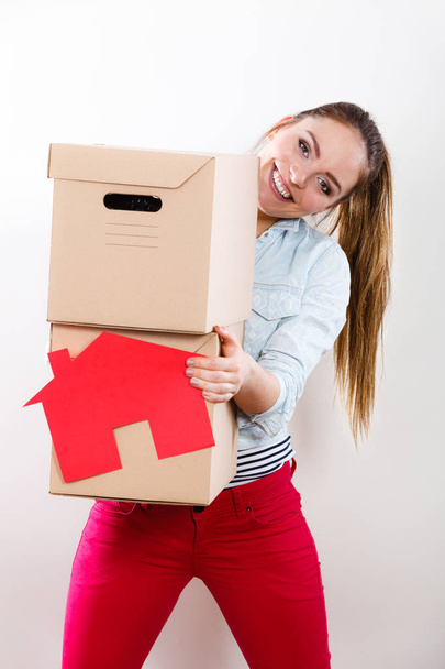 Woman moving into home with boxes and paper house. - Φωτογραφία, εικόνα