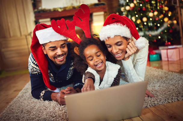 lovely family sharing laptop near the Christmas tree on a winter - Foto, Imagem