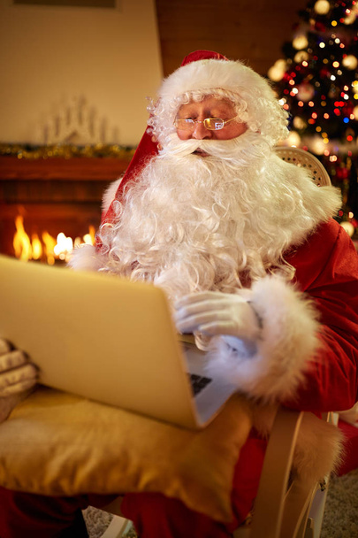 Real Santa Claus using laptop to communicating with children  - Foto, imagen