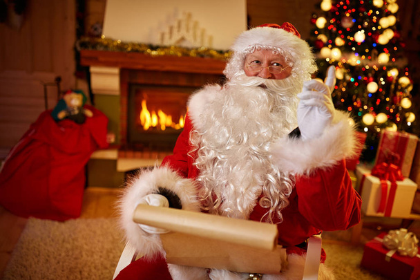 Portrait of happy Santa Claus with wish list - Фото, изображение