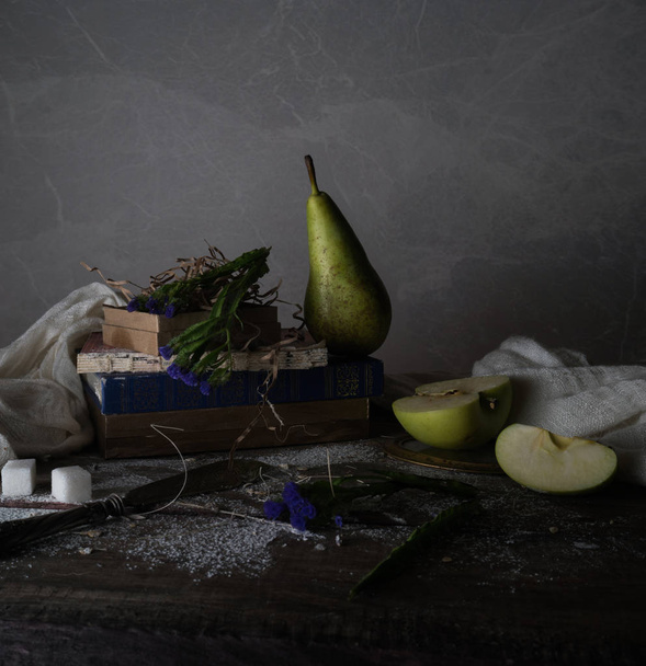 still life, vintage. old books, bouquet of flowers, drapery on a wooden table. dark backgrounds - Foto, afbeelding