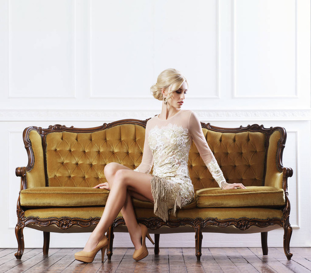 Beautiful woman standing near vintage sofa - Fotó, kép