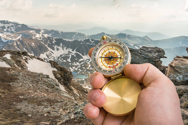 Reisender Mann mit Kompass auf der Suche nach dem richtigen Weg in den Bergen - Foto, Bild