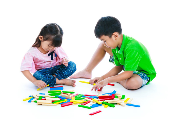 Gyerekek játszanak toy fa blokkok, elszigetelt fehér background.  - Fotó, kép