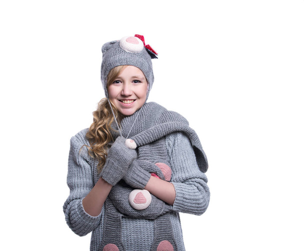 Lovely cheerful teenage girl wearing fuzzy sweater, scarf, mittens and hat isolated on white background. Winter clothes. - Zdjęcie, obraz