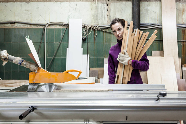 Women worker using saw machine to make furniture at carpenters w - Photo, Image