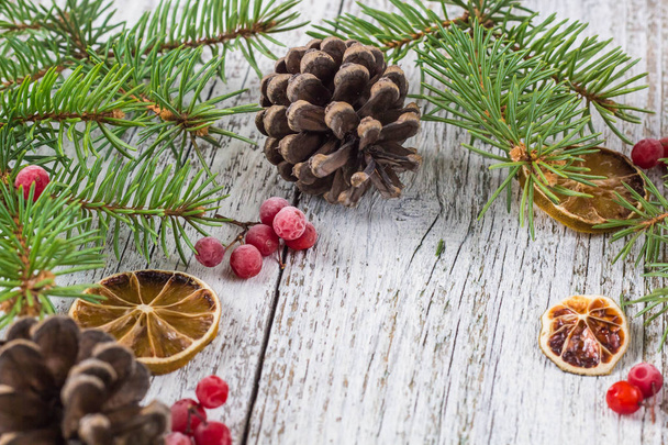 Різдвяні гілки з шишками ягоди вітряної кістки і сухий шматочок лимона
 - Фото, зображення