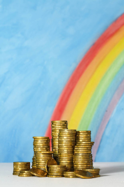 Monedas de oro del dólar australiano contra un cielo azul y arco iris espalda
 - Foto, imagen