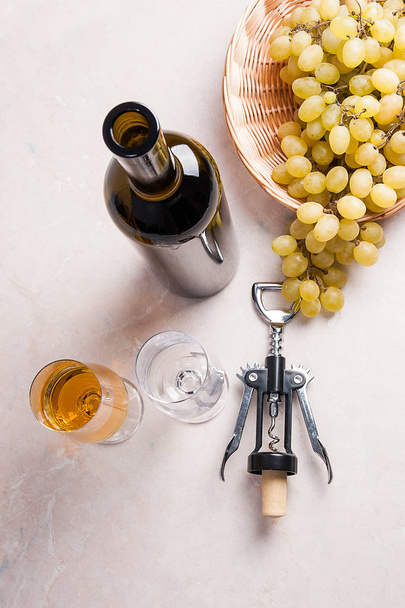Vino blanco y uvas. Vino blanco en vaso, botella, sacacorchos y
 - Foto, Imagen