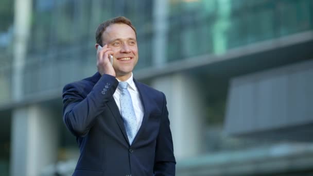 Attractive businessman talking on the phone in city - Felvétel, videó