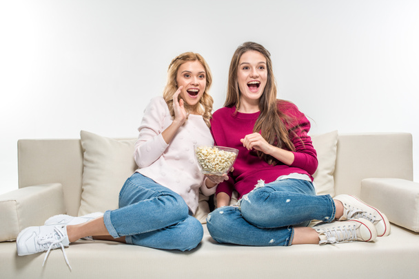 Friends eating popcorn on couch - Фото, зображення