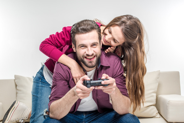 Woman hugging man playing with joystick - Photo, Image