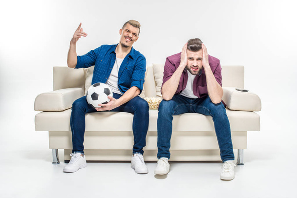 Friends sitting on couch with soccer ball   - Fotografie, Obrázek