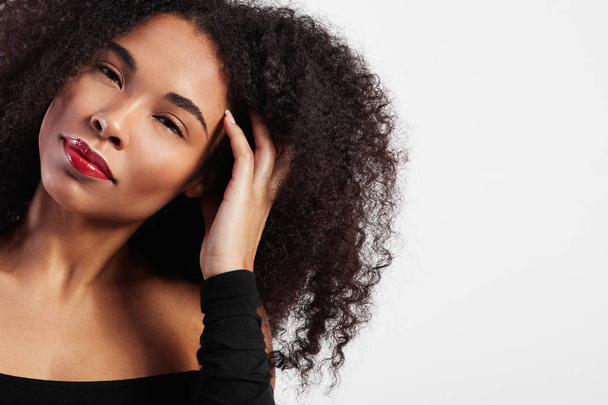 black woman with afro hair touches it  - Foto, Bild