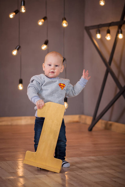 Little boy stands behind number one year - Valokuva, kuva