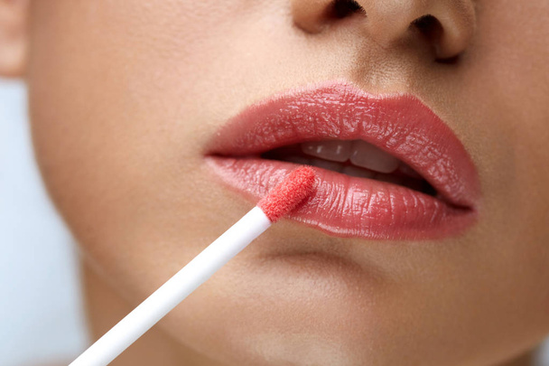 Beauty Makeup. Beautiful Woman Applies Lip Gloss - Foto, immagini