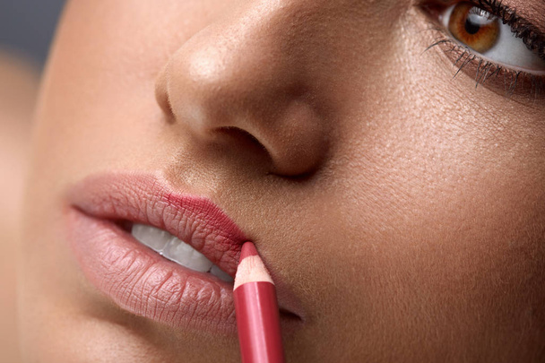 Обличчя макіяж. Красива жінка, використовуючи губи ручка, олівець для губ  - Фото, зображення