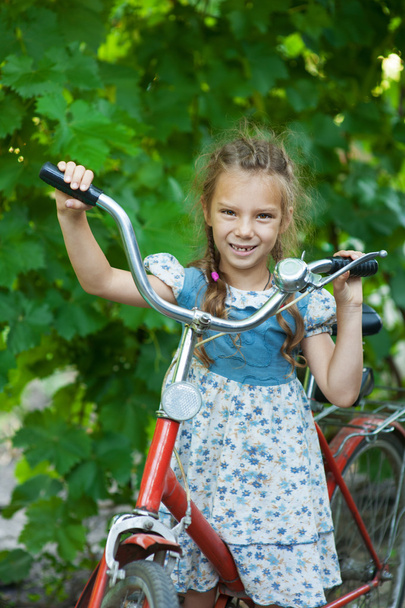 bela menina sorridente com bicicleta infantil
 - Foto, Imagem