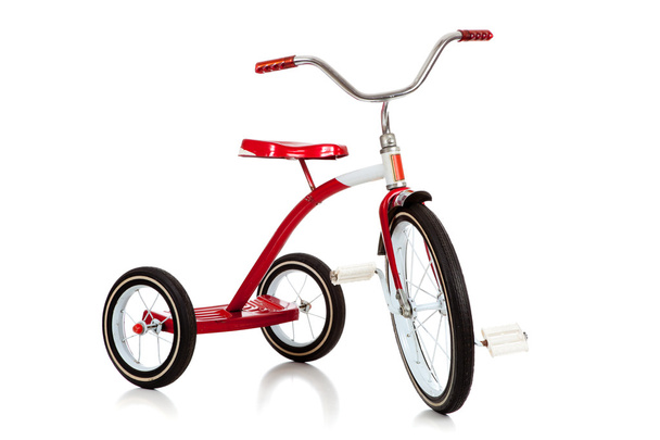 A red toy tricycle on a white background with copy space - Фото, изображение