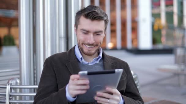 Handsome man using tablet computer near the modern business center, skyscraper, Mall (slider shot) - Materiał filmowy, wideo