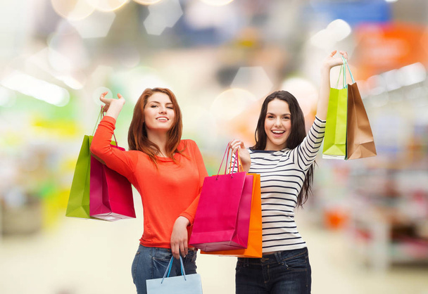 teenage girls with shopping bags and credit card - Foto, afbeelding