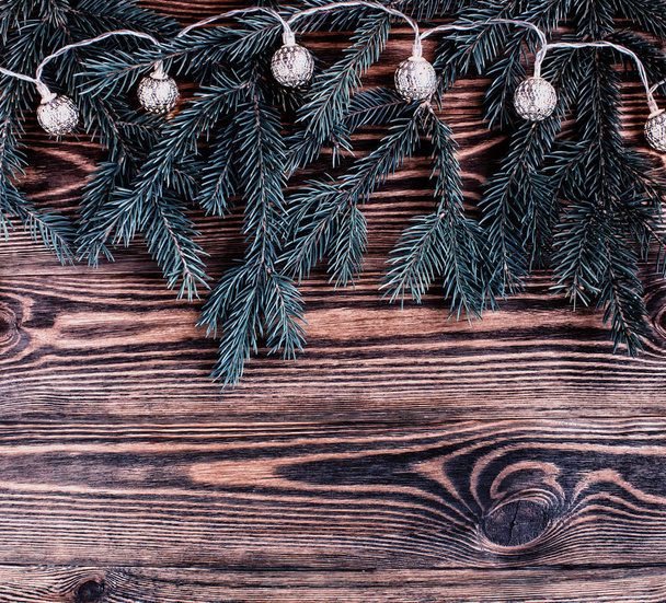 クリスマス ヴィンテージ ガーランドと木製の背景に青のモミの枝正方形構成。ストリング ライト. - 写真・画像