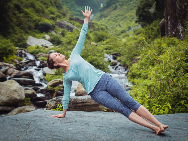 Mulher fazendo ioga asana Vasisthasana - prancha lateral posar ao ar livre - Foto, Imagem