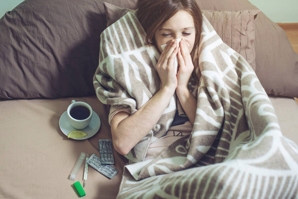 jonge vrouw ziek met een koude liggend in bed - Foto, afbeelding