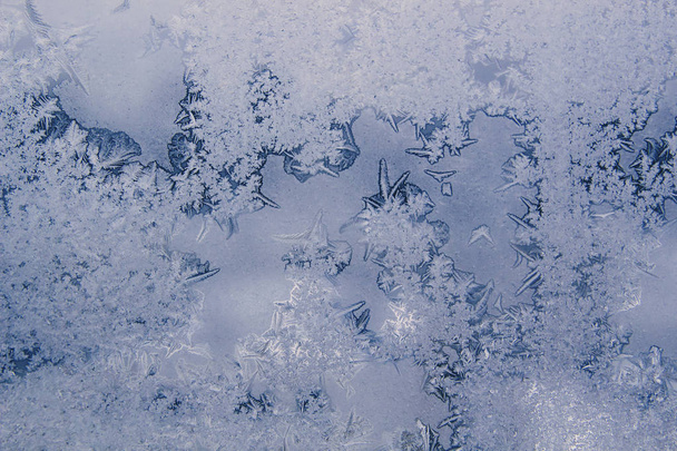 Fond d'hiver avec des motifs de givre glacé sur la fenêtre
. - Photo, image