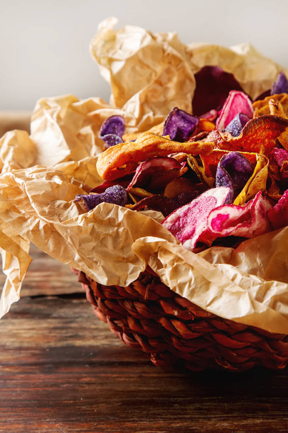 Beet and carrot salty chips on baking paper in an old brown wick - Fotoğraf, Görsel