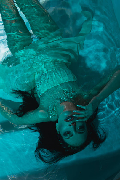 beautiful girl in a dress dives under the water - Foto, imagen