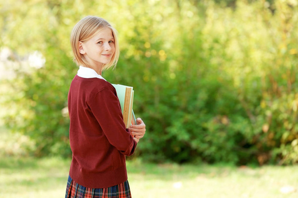 Schoolgirl with books outdoors - Photo, image