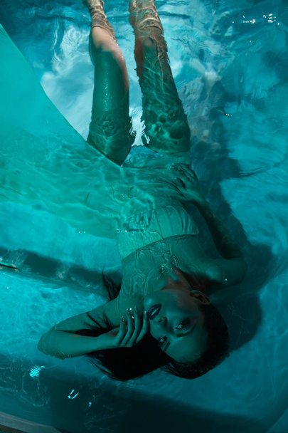 beautiful girl in a dress dives under the water - Photo, Image