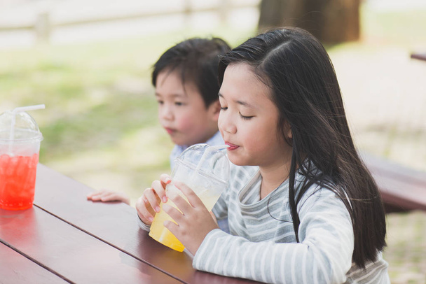 lindo asiático niños beber fresco jugo
 - Foto, imagen