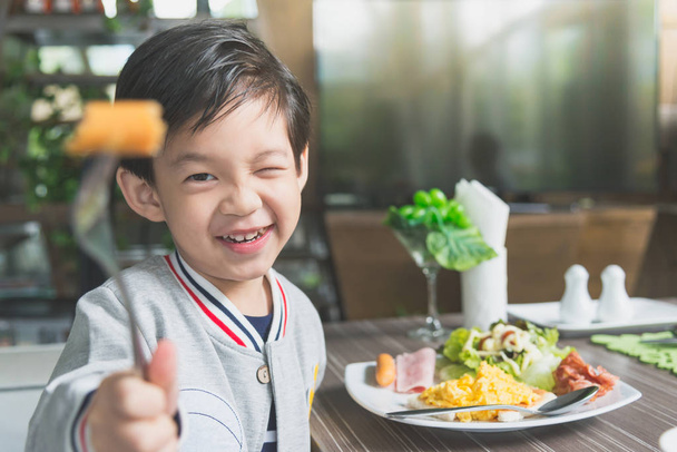 Asian child eating breakfast - Foto, afbeelding