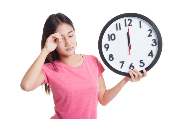 Sleepy young Asian woman with a clock in the morning. - Foto, immagini