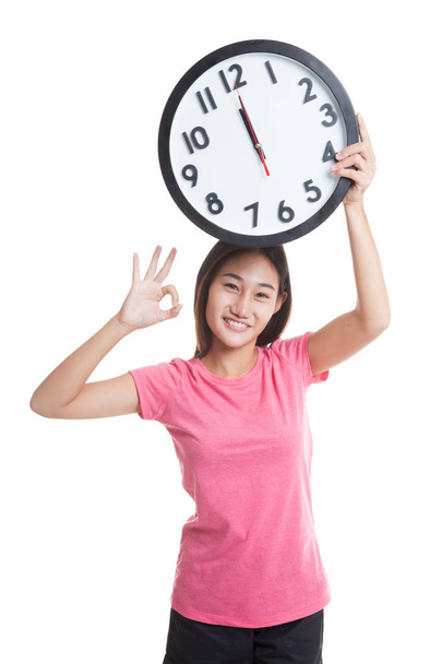 Young Asian woman show OK with a clock. - Foto, Imagen