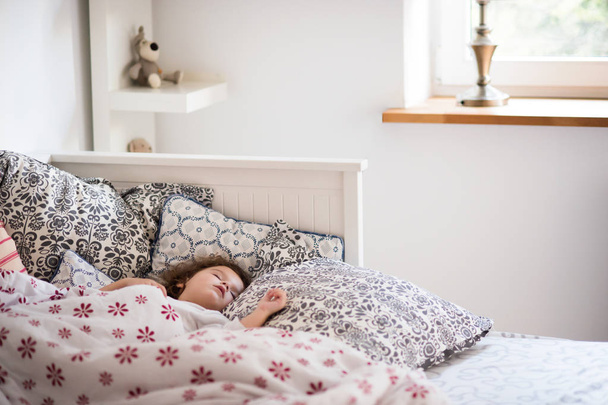 Little girl with smartphone lying in a bed, bedtime - Foto, immagini